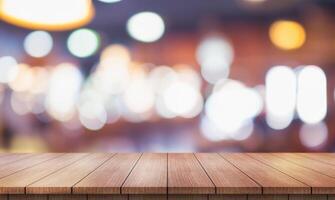 Empty wooden table top with lights bokeh on blur restaurant background. photo