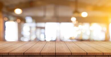 Empty wooden table top with lights bokeh on blur restaurant background. photo