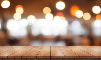 Empty wooden table top with lights bokeh on blur restaurant background. photo