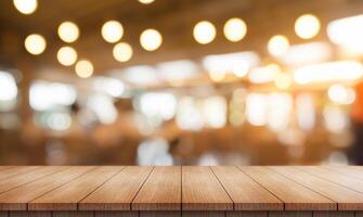 Empty wooden table top with lights bokeh on blur restaurant background. photo