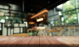 Empty wooden table top with lights bokeh on blur restaurant background photo