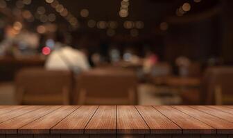 Empty wooden table top with lights bokeh on blur restaurant background photo