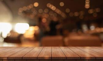 Empty wooden table top with lights bokeh on blur restaurant background photo