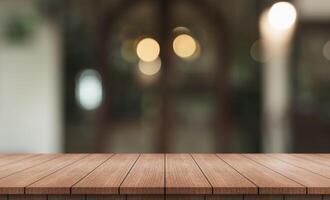 Empty wooden table top with lights bokeh on blur restaurant background. photo