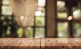 Empty wooden table top with lights bokeh on blur restaurant background. photo