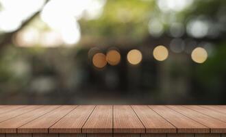 Empty wooden table top with lights bokeh on blur restaurant background. photo