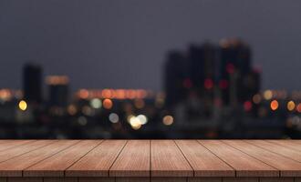 wood table with blurred night city skyline background photo