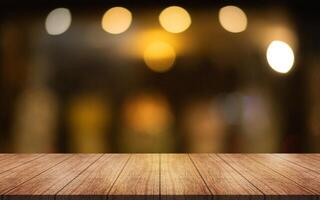 Empty wooden table top with lights bokeh on blur restaurant background. photo