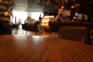 Empty wooden table top with lights bokeh on blur restaurant background photo