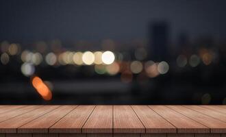 wood table with blurred night city skyline background photo