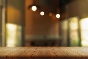 Empty wooden table top with lights bokeh on blur restaurant background. photo