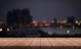 wood table with blurred night city skyline background photo