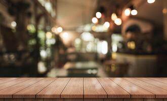 Empty wooden table top with lights bokeh on blur restaurant background. photo