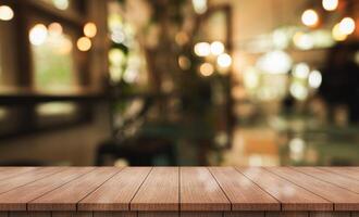 Empty wooden table top with lights bokeh on blur restaurant background. photo