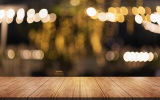 Empty wooden table top with lights bokeh on blur restaurant background. photo