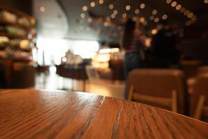 vacío de madera mesa parte superior con luces bokeh en difuminar restaurante antecedentes foto
