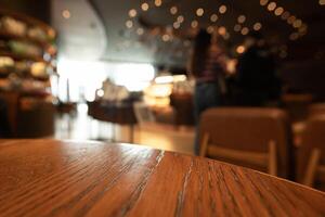 Empty wooden table top with lights bokeh on blur restaurant background photo