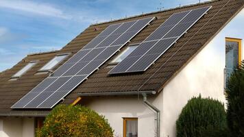 Home solar panel. Alternative energy is used for heating and water heating. Eco-friendly alternative energy for house. Residential family house suburban. Brown tile roof of home with solar panels. photo