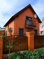 private red brick house with a fence photo