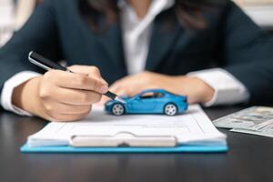 Dealership offered various finance options, including an auto loan or lease, making it easier to buy or rent a car from the company. Agent reviewed contract, finalizing insurance agreement. photo