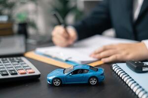 Dealership offered various finance options, including an auto loan or lease, making it easier to buy or rent a car from the company. Agent reviewed contract, finalizing insurance agreement. photo