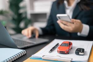 Dealership offered various finance options, including an auto loan or lease, making it easier to buy or rent a car from the company. Agent reviewed contract, finalizing insurance agreement. photo