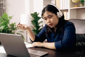 contento alumno, estudiando para MBA examen, toma ventaja de distancia aprendizaje a atender colegio desde hogar, equilibrio formación y clase. mujer estudios libro y investigación para en línea academia utilizando ordenador portátil. foto