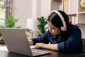 contento alumno, estudiando para MBA examen, toma ventaja de distancia aprendizaje a atender colegio desde hogar, equilibrio formación y clase. mujer estudios libro y investigación para en línea academia utilizando ordenador portátil. foto