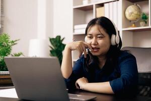 contento alumno, estudiando para MBA examen, toma ventaja de distancia aprendizaje a atender colegio desde hogar, equilibrio formación y clase. mujer estudios libro y investigación para en línea academia utilizando ordenador portátil. foto