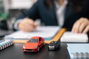 Dealership offered various finance options, including an auto loan or lease, making it easier to buy or rent a car from the company. Agent reviewed contract, finalizing insurance agreement. photo