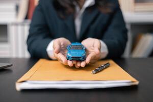 Dealership offered various finance options, including an auto loan or lease, making it easier to buy or rent a car from the company. Agent reviewed contract, finalizing insurance agreement. photo