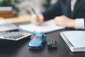 Dealership offered various finance options, including an auto loan or lease, making it easier to buy or rent a car from the company. Agent reviewed contract, finalizing insurance agreement. photo