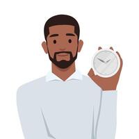 Smiling man points finger at alarm clock to remind of beginning or end of lunch break. vector