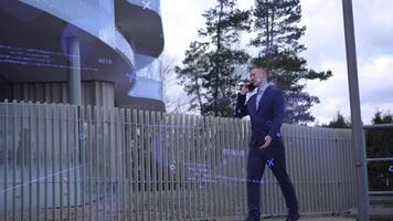 Businessman strides with purpose phone to ear, against office building backdrop Businessman discusses critical deals, focused and assertive. Businessman's steps mirror his professional determination video