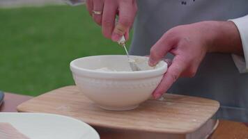 kneading dough with a spoon in a bowl, cooking in the yard video