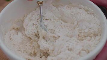 kneading dough with a spoon in a bowl, cooking outdoors video