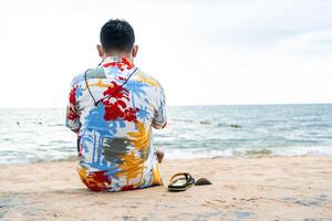 Alone young man relax sitting on beach stone walkways and concentrated in summer. Calm weather. photo