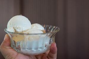 Three scoops of coconut ice cream lie in a bowl glass. photo