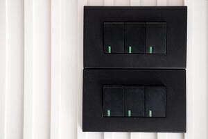 Two pairs of Black light switches on white wall photo