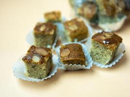 Mini square cut of sweet and soft banana cake served on paper cup. Selective focus. photo