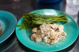 Raw and fresh oyster served with acacia vegetables. photo