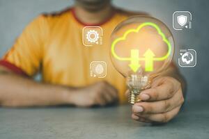 A man holding light bulb with virtual cloud computing to transfer database information upload, Protect data photo