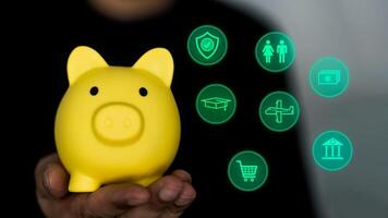 Hand holding a piggy bank and planning money icons. Concept of savings, investments or returns photo