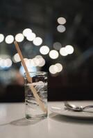 Glass of water with ice on cafe bokeh blurred background. photo