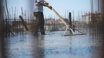 Worker leveling poured concrete at the construction site video