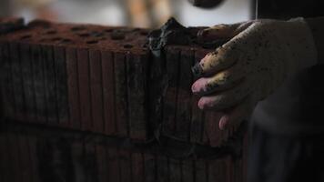 Hands of builder laying brick wall video