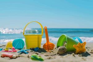 Children's toys lie on the sand. Small sea waves are visible in the background. Summer rest photo