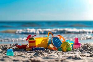 Children's toys lie on the sand. Small sea waves are visible in the background. Summer rest photo