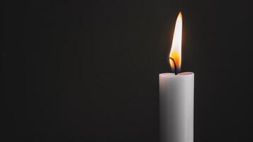 Burning white candle on black background. Close-up photo. With copy space. Image for memory of events and people photo