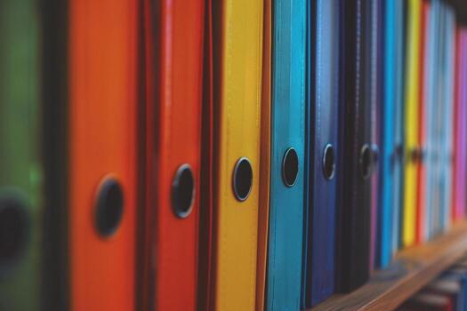 A large number of colored binders for documents standing in row on shelf photo